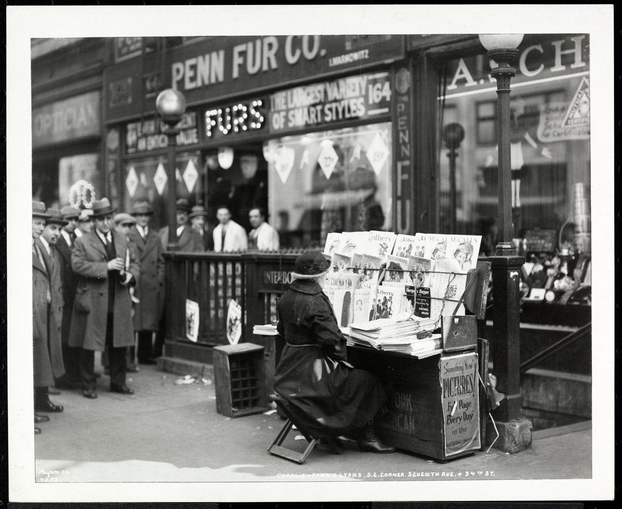 Marchand de journaux aveugle, Aaron Weintraub, à son stand au coin sud-est de la 7e Avenue et de la 32e Rue, New York, 1926 - Byron Company