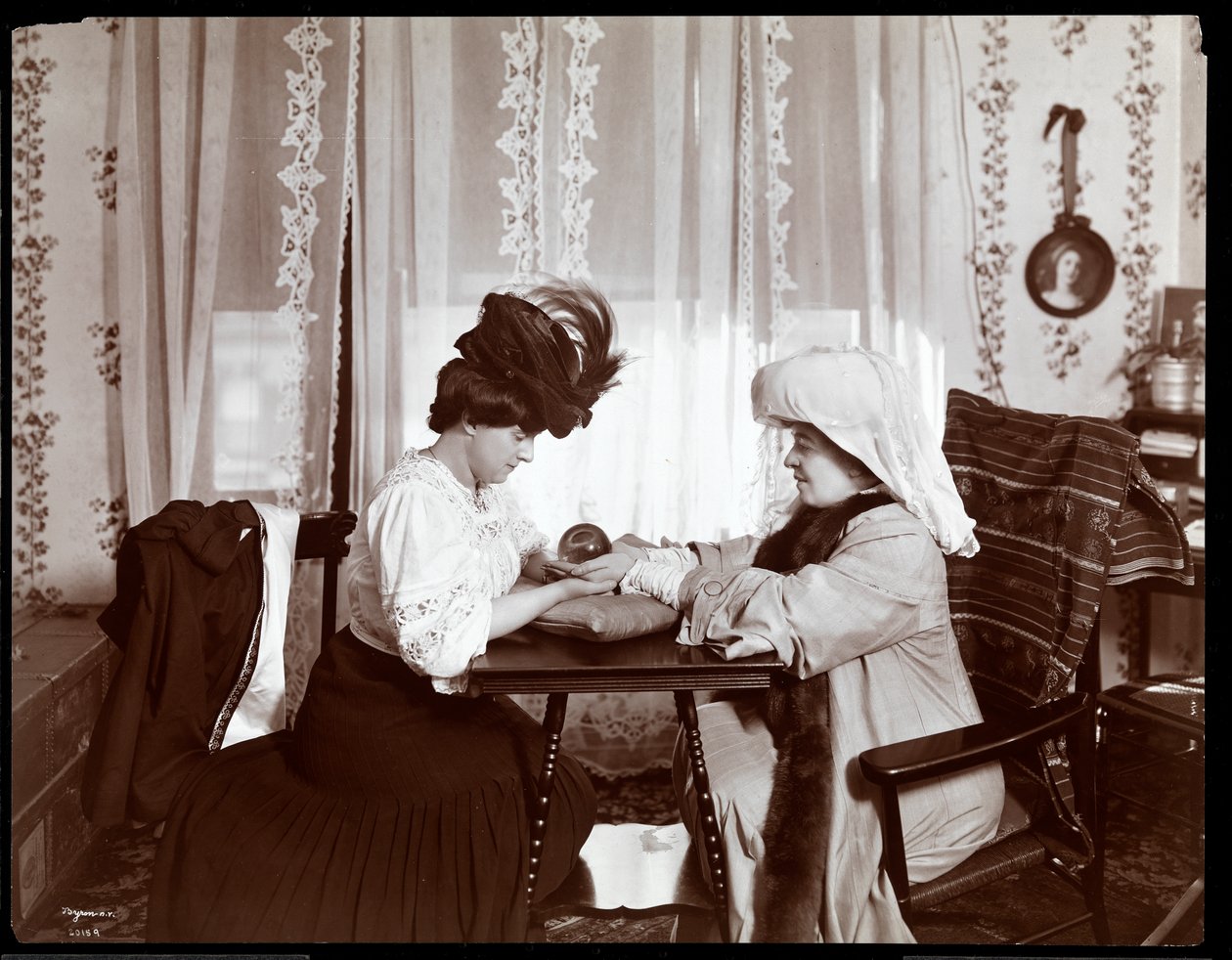 Mme Leslie Carter assise avec une femme lisant une boule de cristal, 1904 - Byron Company