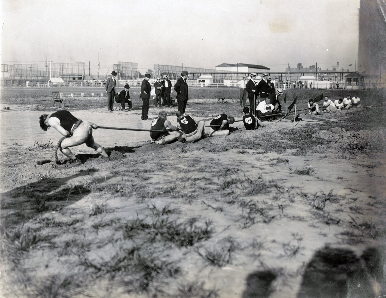 Photographie horizontale de deux équipes en compétition de tir à la corde. Il y a des juges derrière la corde. Les ombres des spectateurs peuvent être vues sur la photographie - Jessie Tarbox Beals