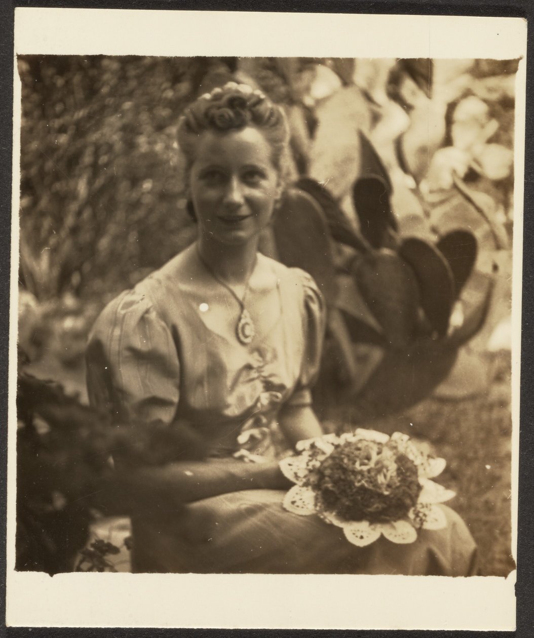 [Femme tenant un bouquet, assise devant un cactus] - Louis Fleckenstein