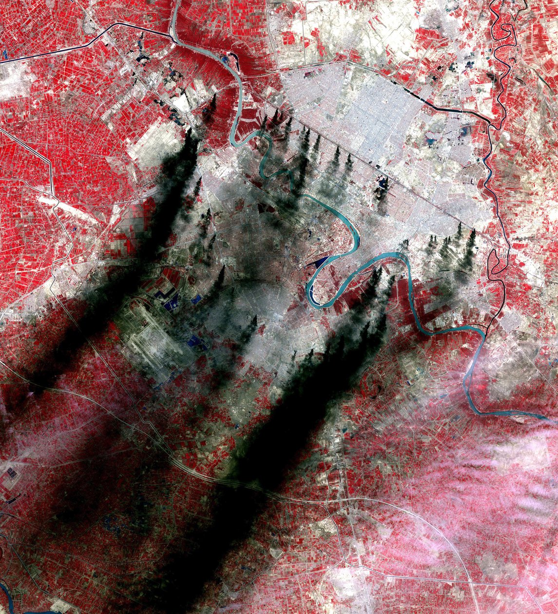 Panaches de fumée au-dessus de Bagdad, Irak, qui proviennent le long des routes principales et des canaux, supposés être des piscines de pétrole brûlant des pipelines. Pris par la NASA pendant l