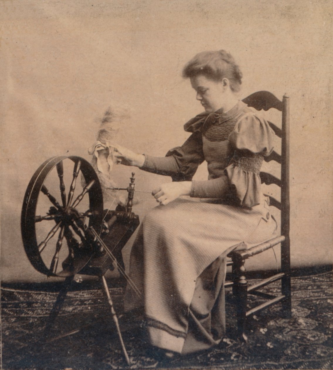 Une dame à un rouet vers 1900 - Unbekannt