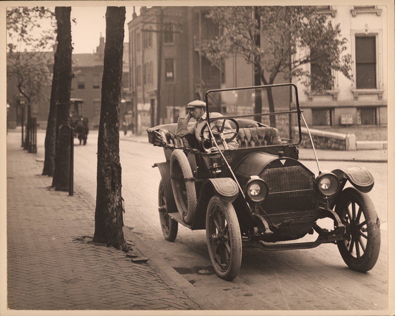 Homme assis dans une automobile dans une rue non identifiée - William G. Swekosky